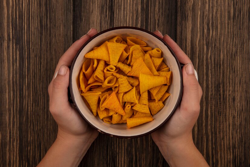 top view female hands holding bowl cone shape corn snacks wooden table